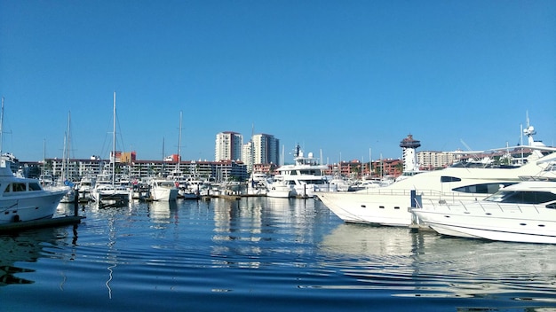 Photo boats moored at harbor against clear blue sky