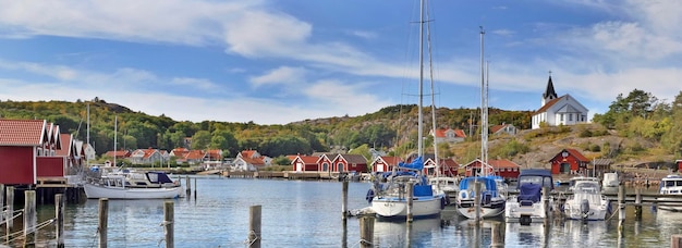 Boats moored in the port and red cabins of a small swedish seaside town Molle