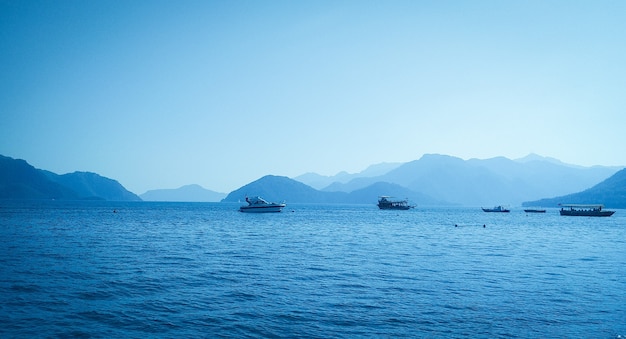 Boats sail on the sea against the backdrop of the mountains