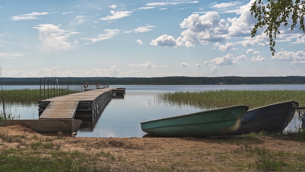 Boats on the shore at the pier against the background of the river