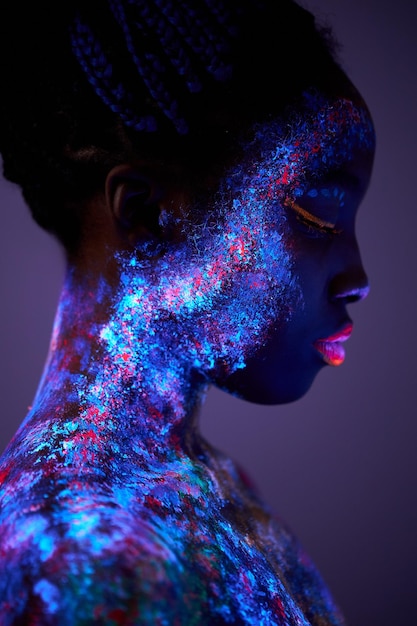 Body art glowing in ultraviolet light closeup face of black female with big lips