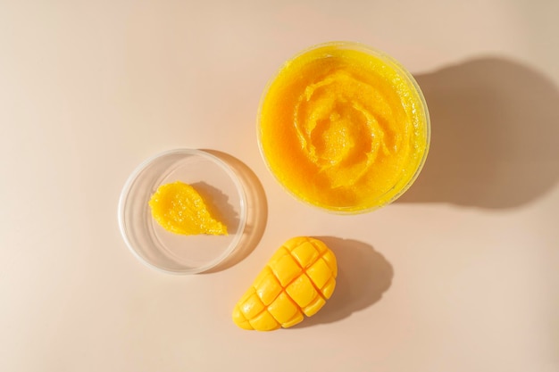 A body care natural mango soap and a yellow cosmetic smudge for spa procedures standing on a beige background