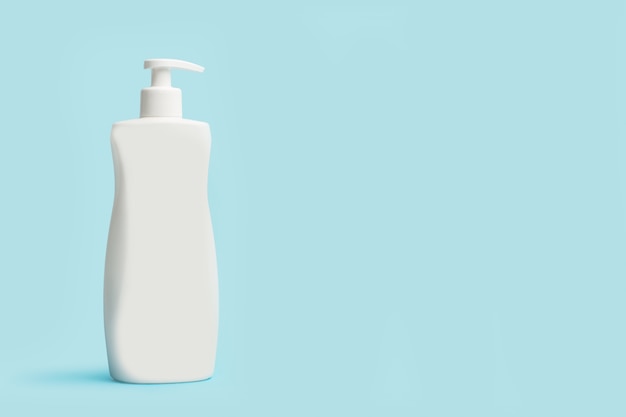 A body cream bottle on a light blue background with copy space