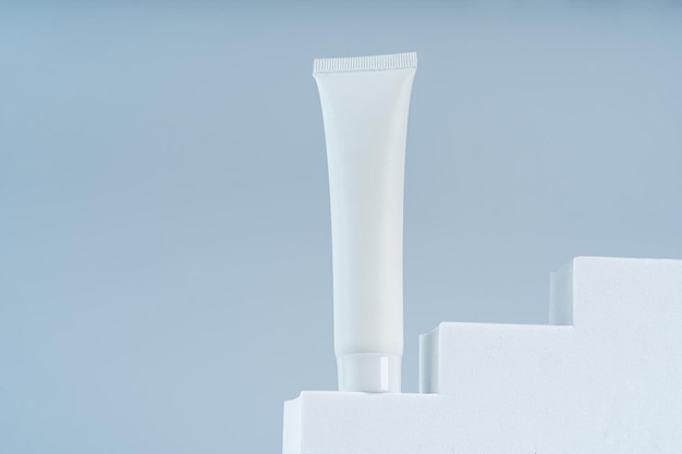 A body or face cream in a white tube template sample on a white podiumm presenting product