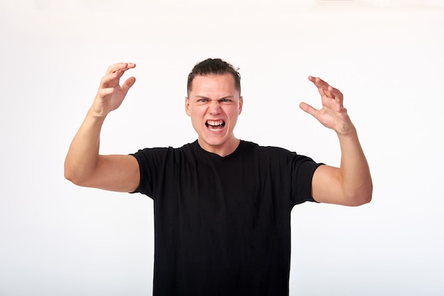 Body language. Men's domination. Angry aggressive unhappy young man in total shirt screaming. Studio shot on white background.