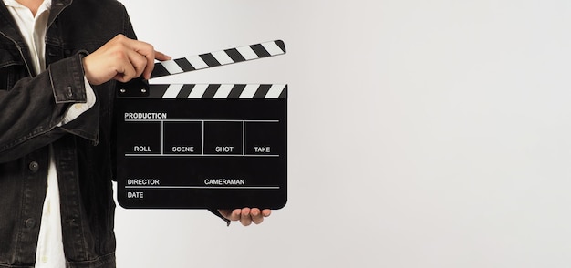 Body part of a man is holding black clapperboard or movie slate on white background Studio shooting