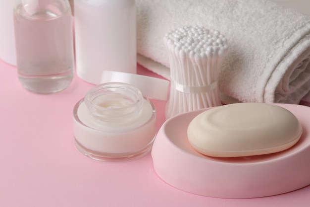 Body and skin care products in white packaging on a pink delicate background. Personal hygiene products.