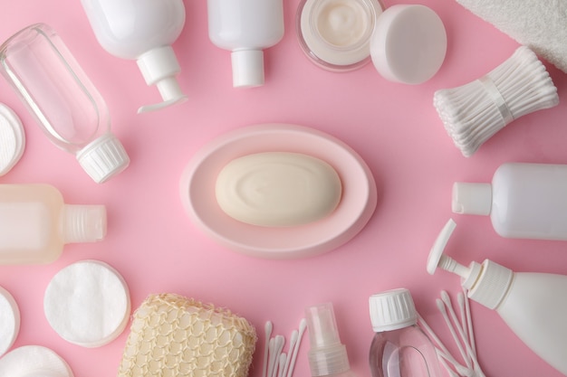 Body and skin care products in white packaging on a pink table