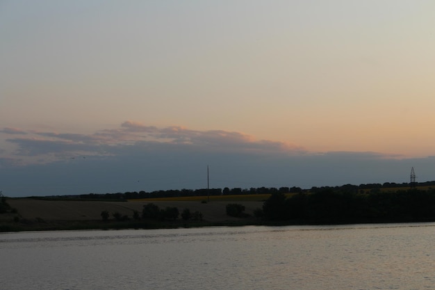 A body of water with a body of water and a field in the background