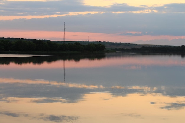 Photo a body of water with trees and a tower in the distance