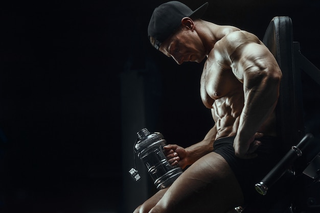 Bodybuilder drinking water after fitness workout