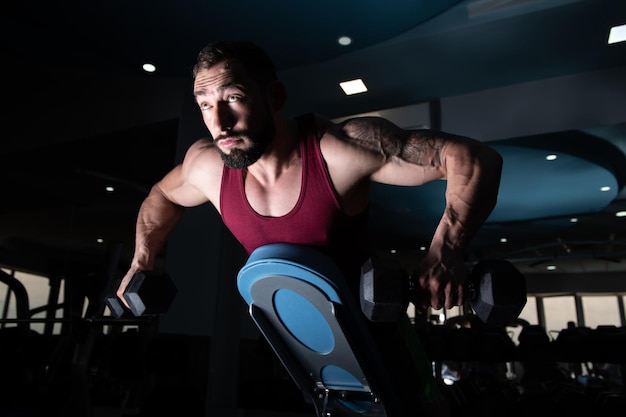 Bodybuilder Exercising Back With Dumbbells