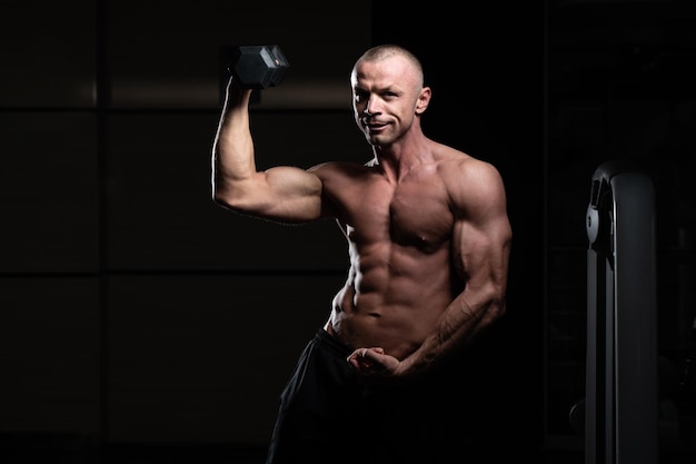 Bodybuilder Exercising Biceps With Dumbbells