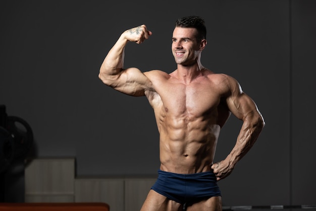 Bodybuilder Fitness Model Posing Biceps After Exercises