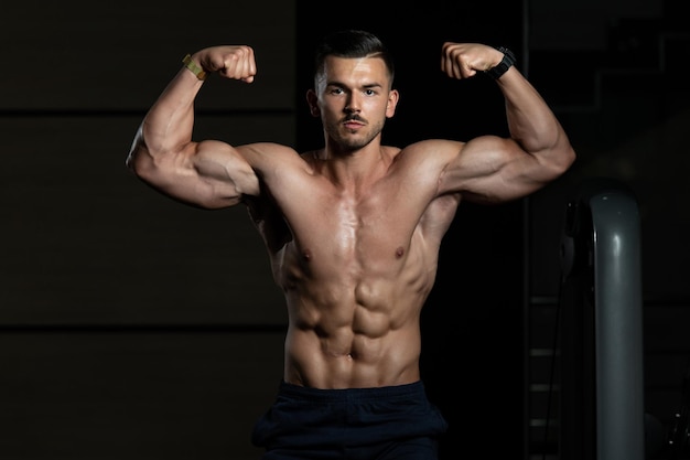 Bodybuilder Performing Front Double Biceps Pose In Gym