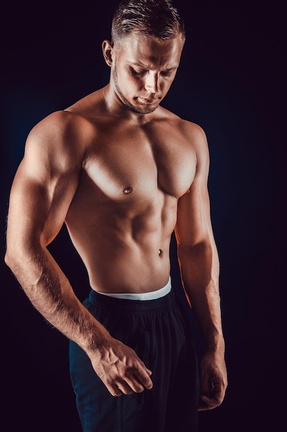 Bodybuilder posing beautiful sporty guy male power fitness muscular body isolated on black background