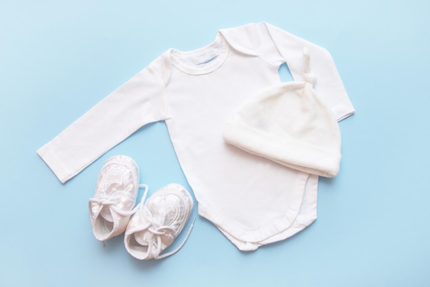 Bodysuit for a newborn cap and booties on a blue background