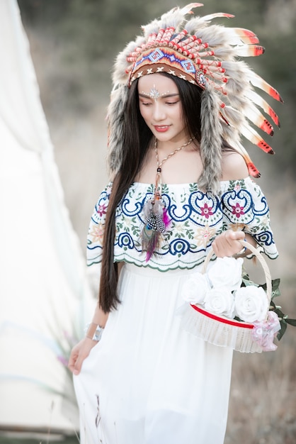 Boho bohemian girl styled wearing Indian maxi dress and jewellery in autumn field