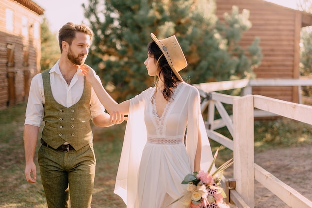 Boho-style newlyweds walk in nature, summer day