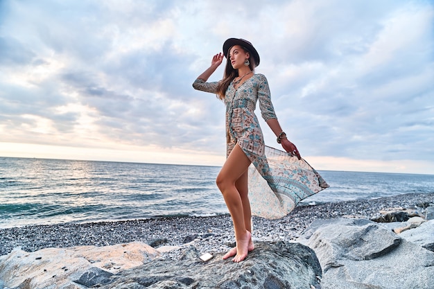 Boho woman with fluttering long dress and felt hat