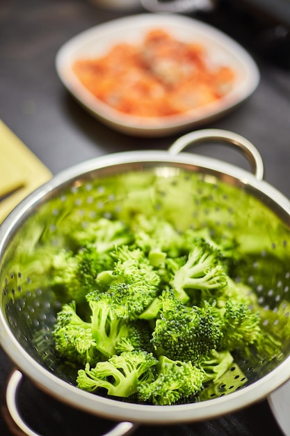 Boiled broccoli in metal colander closeup