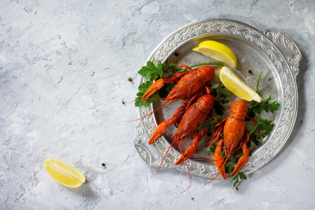 Photo boiled crawfish lemon and parsley on a concrete background