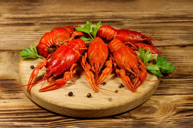 Boiled crayfish on cutting board on wooden table