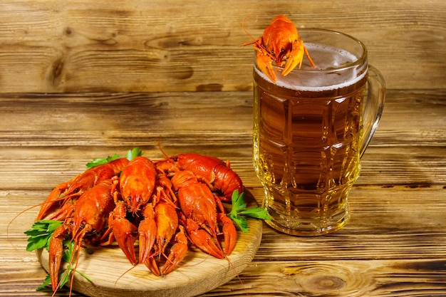 Boiled crayfish and mug of beer on a wooden table