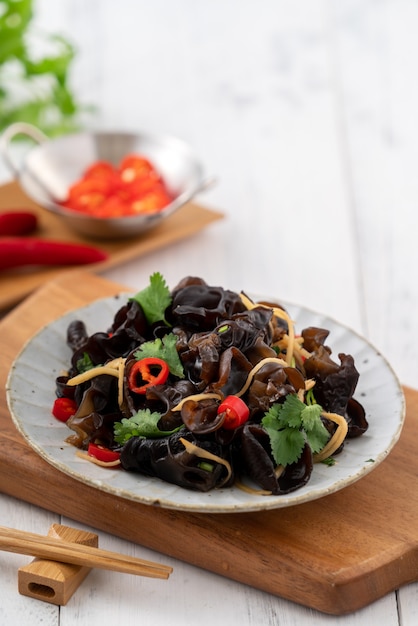 Boiled edible tree black fungus, wood ear in a plate on white table surface.