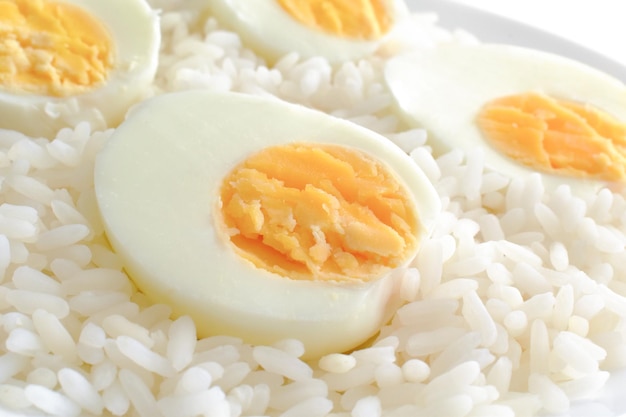 Boiled egg on rice on a white plate