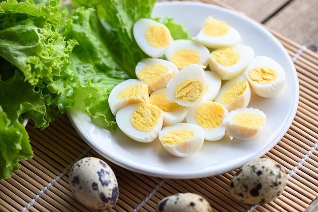 Boiled eggs food quail eggs on white plate breakfast eggs with fresh quail eggs and vegetable coriander on wooden table background