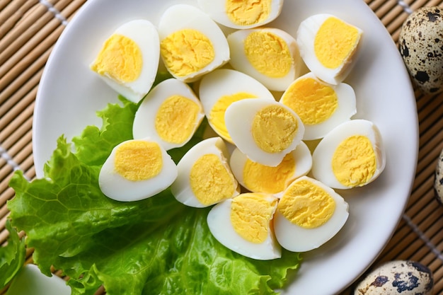 Boiled eggs food quail eggs on white plate breakfast eggs with fresh quail eggs and vegetable lettuce salad on wooden table background