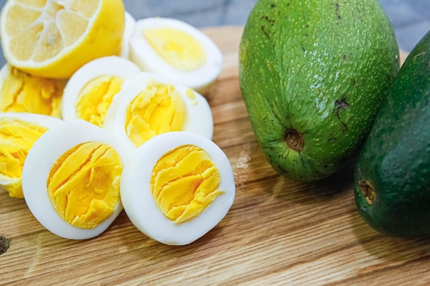 boiled eggs with avocado on a wooden board