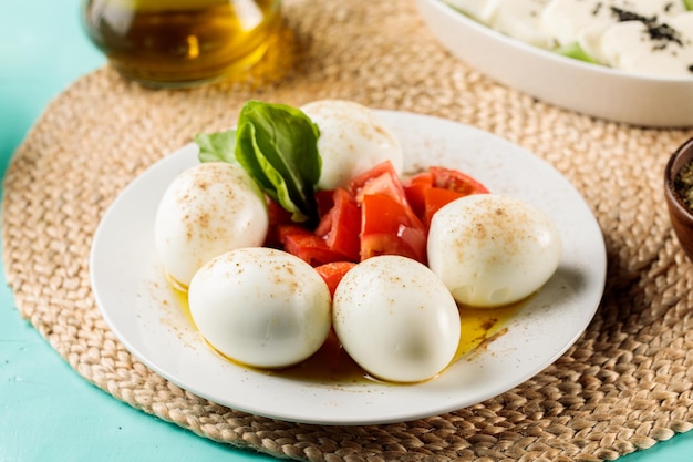 Boiled Eggs with tomatoes served in a dish isolated on cutting board side view