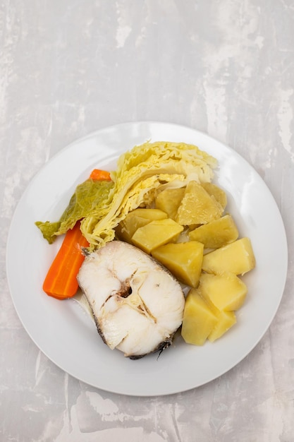 Boiled fish with boiled potato carrot and cabbage