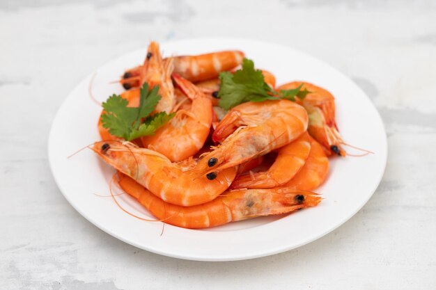 Boiled fresh shrimps with parsley on white small dish