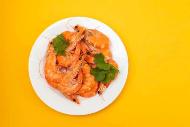 Boiled fresh shrimps with parsley on white small dish