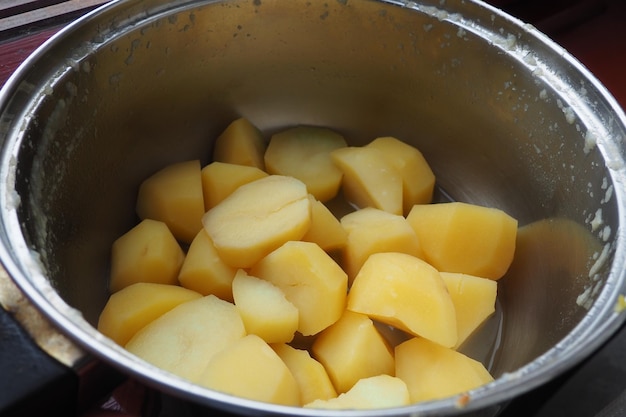 Boiled lumpy potatoes in a metal pan top view Boiled chopped pieces of peeled potatoes Cooking food Thermal processing of food products Food ingredients for cooking Yellow potato