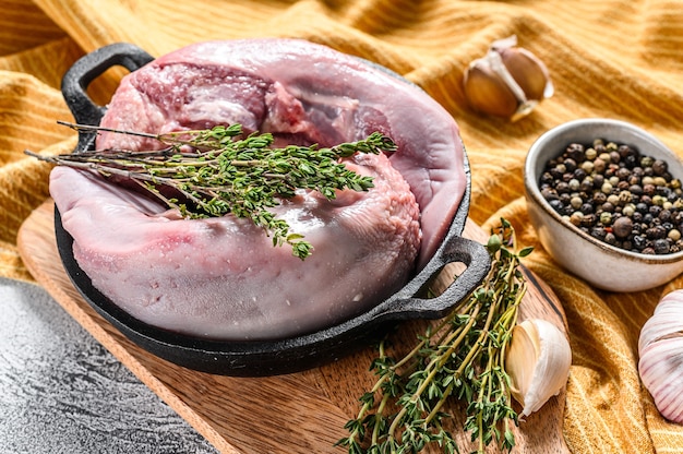 Boiled pork tongue with spices and herbs. Organic meat offal. White background. Top view.