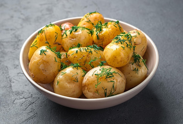 Boiled potatoes with dill and butter closeup on a dark background