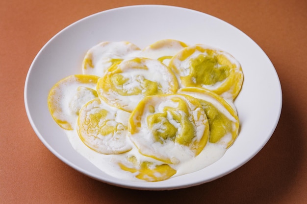 Boiled ravioli with sour cream on plate