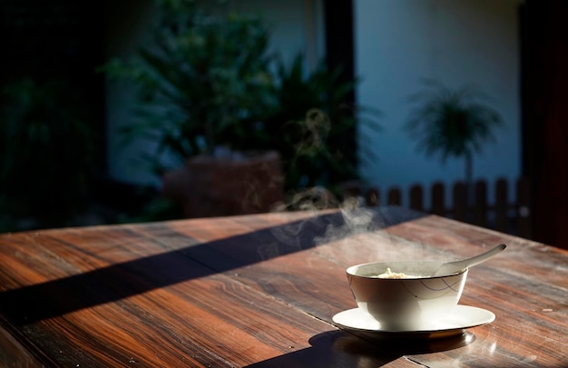 A boiled rice dish with beautiful steam on a wooden table in a morning