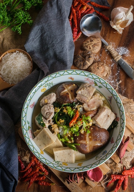 Boiled rice with pork, porn bone and thai pork sausage in bowl