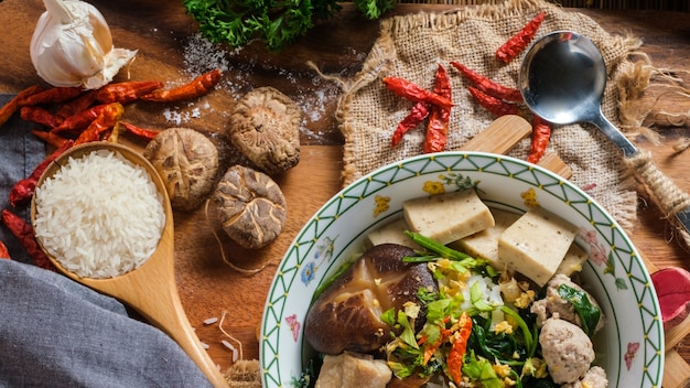 Boiled rice with pork, porn bone and thai pork sausage in bowl.