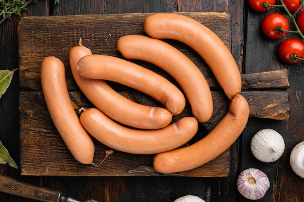 Boiled sausage set, on old dark  wooden table background, top view flat lay