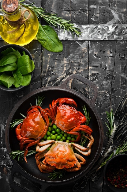 Boiled sea crabs with vegetables in a black pan Seafood Top view Free space for your text