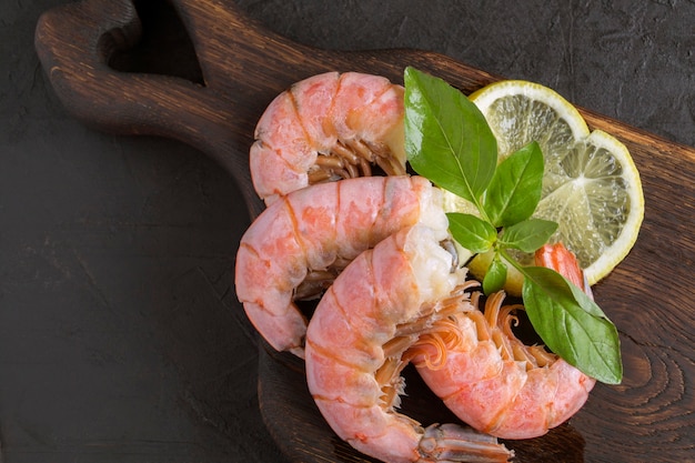 Boiled shrimp with lemon on a wooden Board.