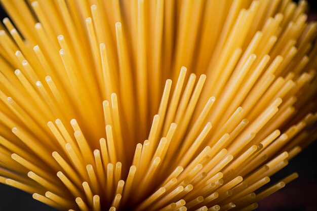 Not boiled spaghetti dry on a black background