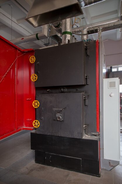 A boiler for heating the premises of a waste processing factory. The boiler runs on combustible waste.