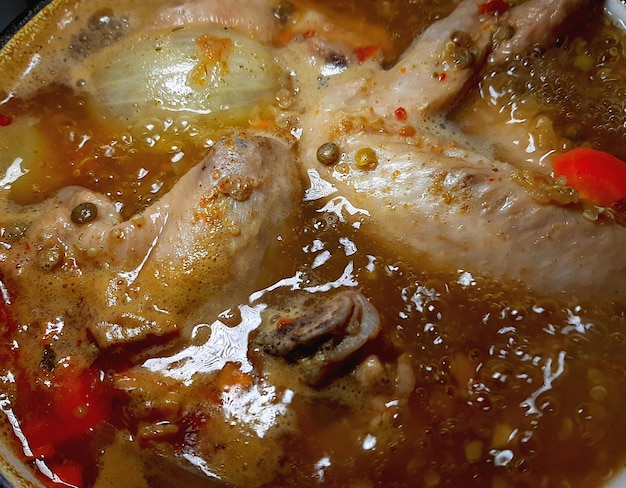 Boiling chicken wings soup with lentils onions carrots spices